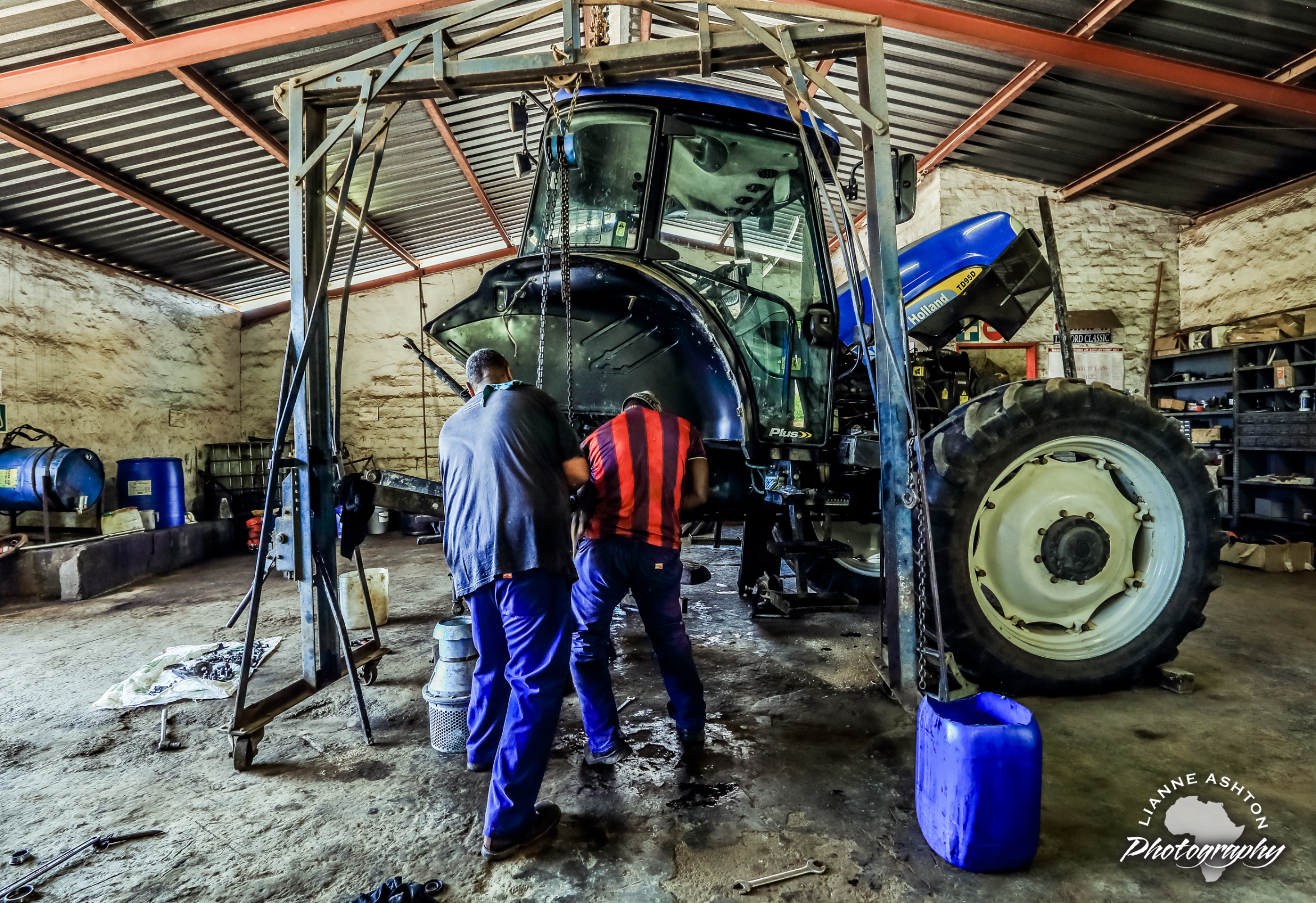 two mechanics repairing a tractor